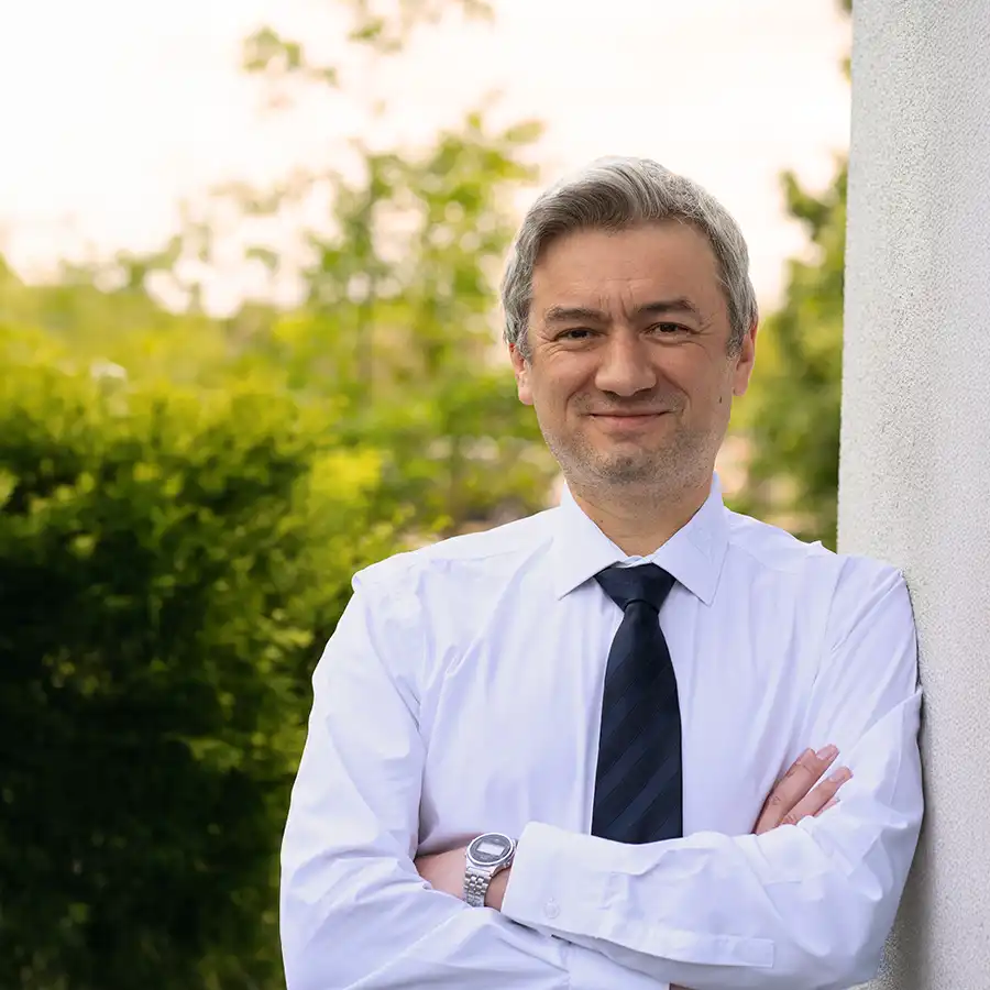 Profilbild Alexander Neu an Hauswand mit Hemd und Krawatte