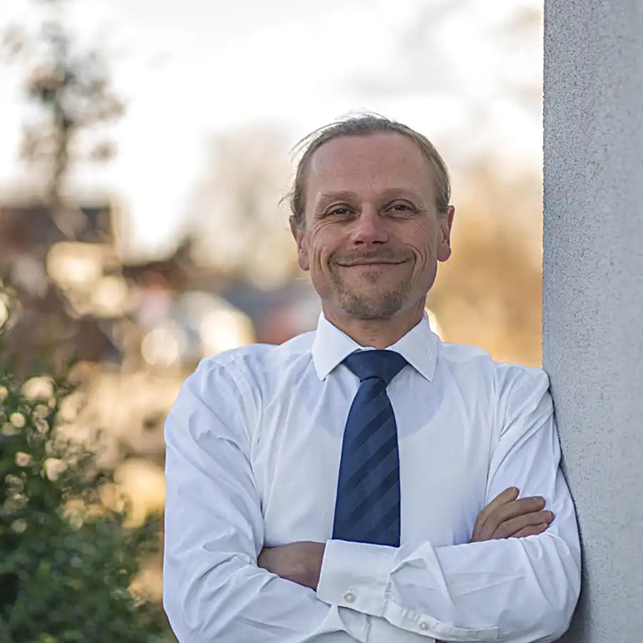 Profilbild Stephan Roland an Hauswand mit Hemd und Krawatte